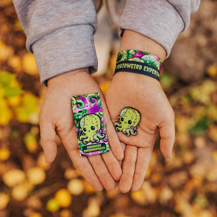 Lifestyle image of someone holding the card in one hand, pin in the other and wearing the back. Background is a pile of leaves.