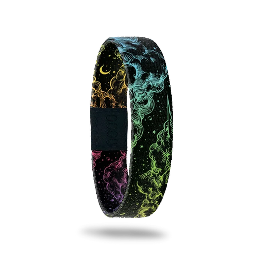An image of a multicolored elastic wristband with a space-themed design, predominantly black with streaks of colorful smoke patterns.